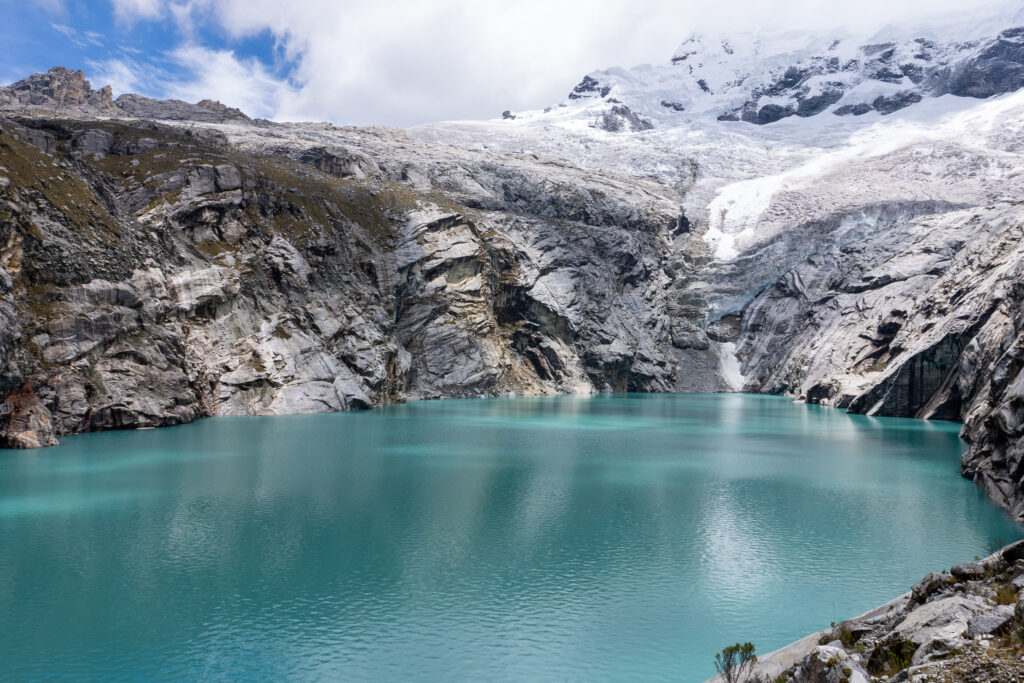 The turquoise Laguna 513 with the backdrop of snow-capped mountains