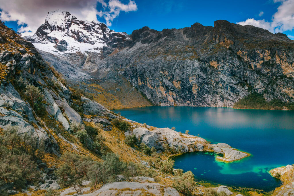 Laguna Churup, a deep blue lake with the mountains of the Cordillera Blanca behind. 