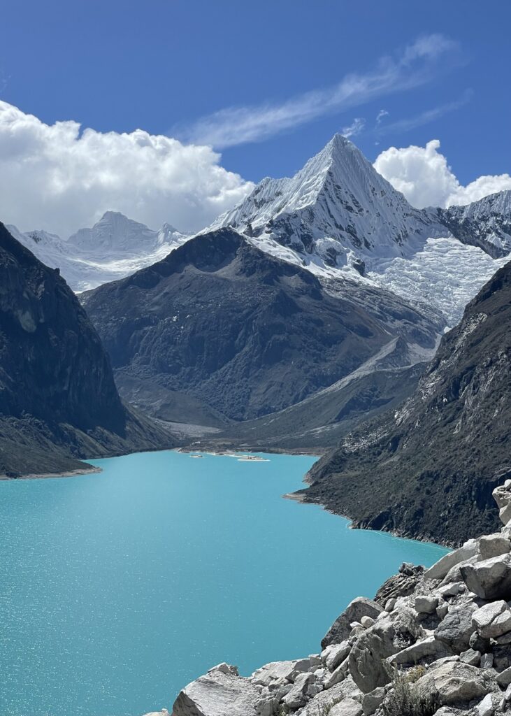 The bright blue lake of Laguna Paron with snow-capped Mountains in the background. 