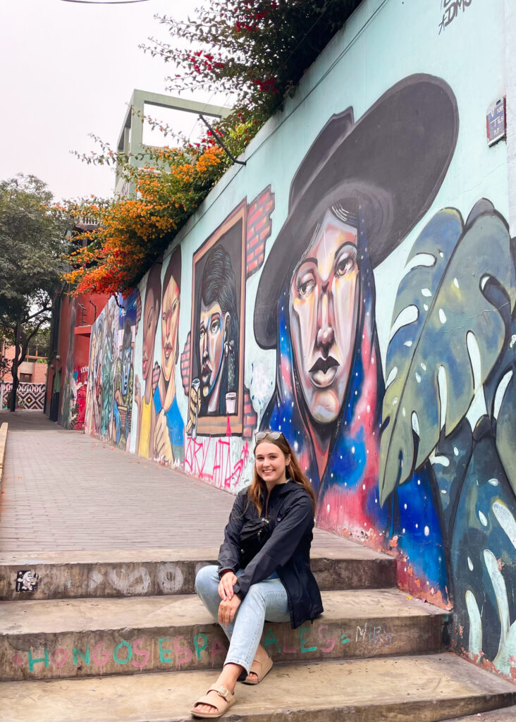 Megan sat in front of a colourful mural in the Barranco neighbourhood.