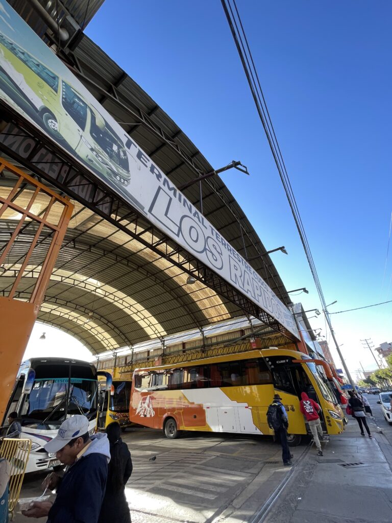 A photo of the bus terminal in Cusco where you catch the bus to Sicuani, showing the terminal sign and a yellow bus