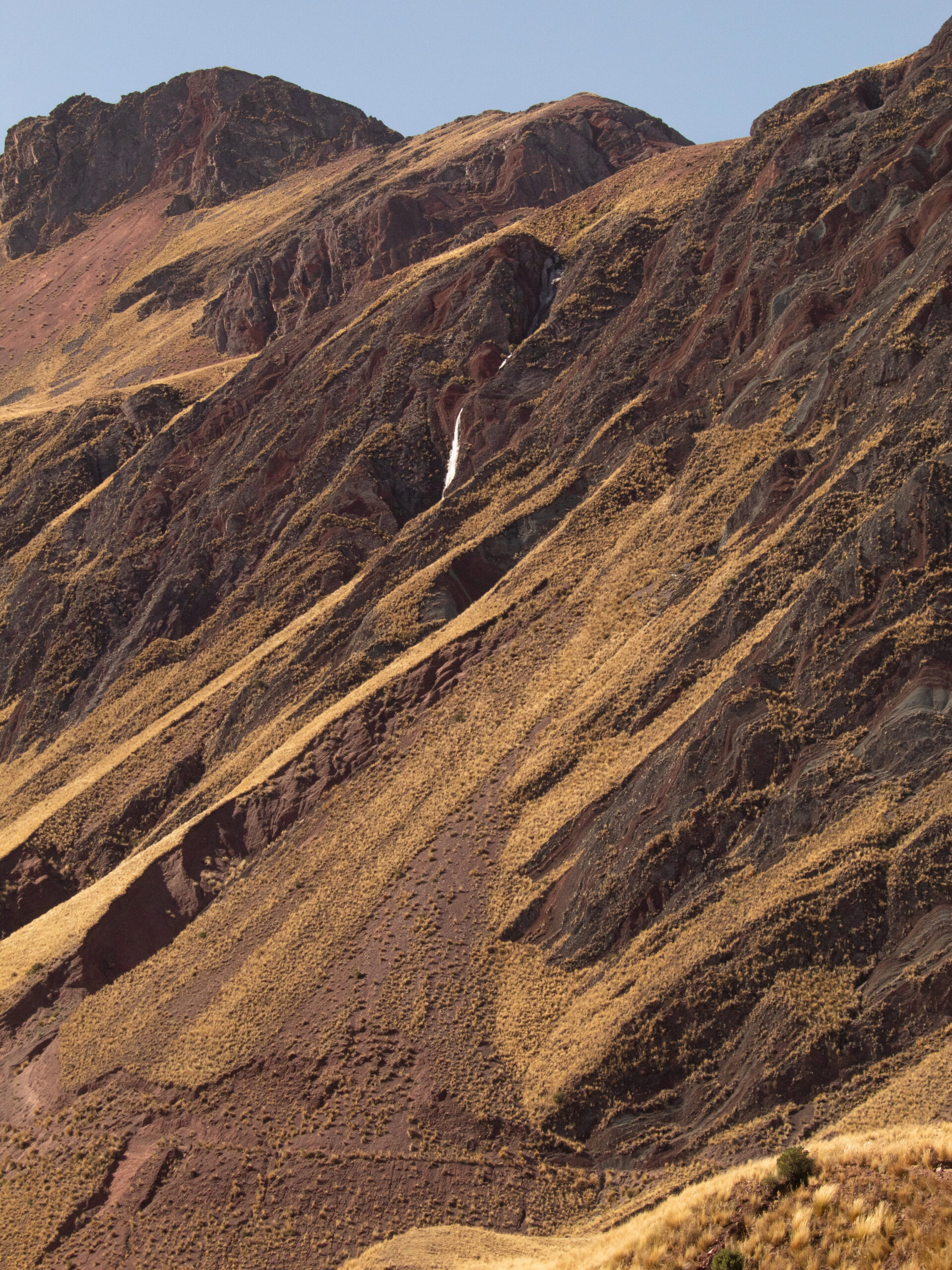 A petrified waterfall peaking through the jagged mountainsides. 