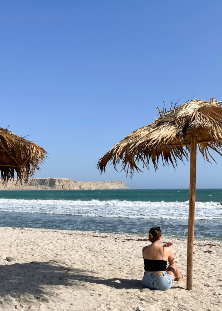 Megan sat under a straw umbrella at Yumaque beach. 
